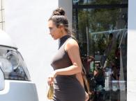 Kim Kardashian kobieco w szarej sukience 